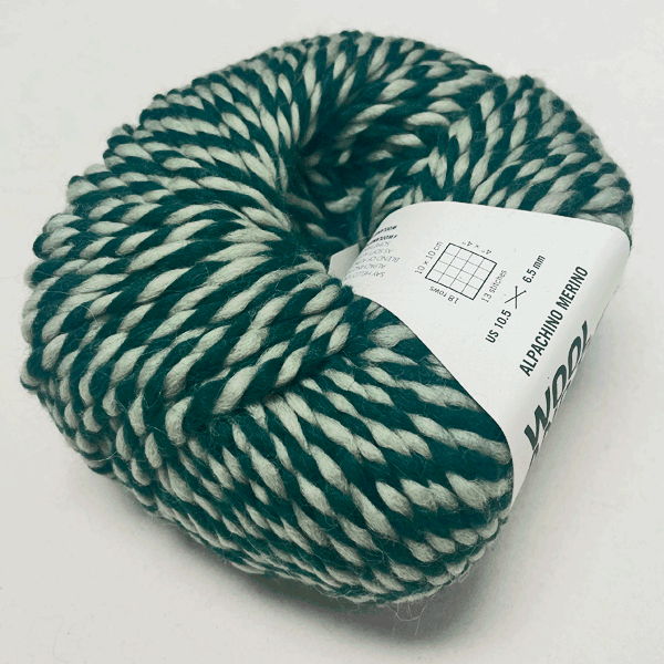Alpachino Merino, Spool of green and white yarn with a label on a light gray background