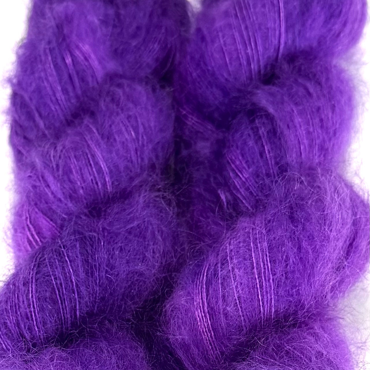 Delicious by Apple Fiber Studio. Two fluffy braided hair extensions in a vibrant purple color, shown against a plain white background.