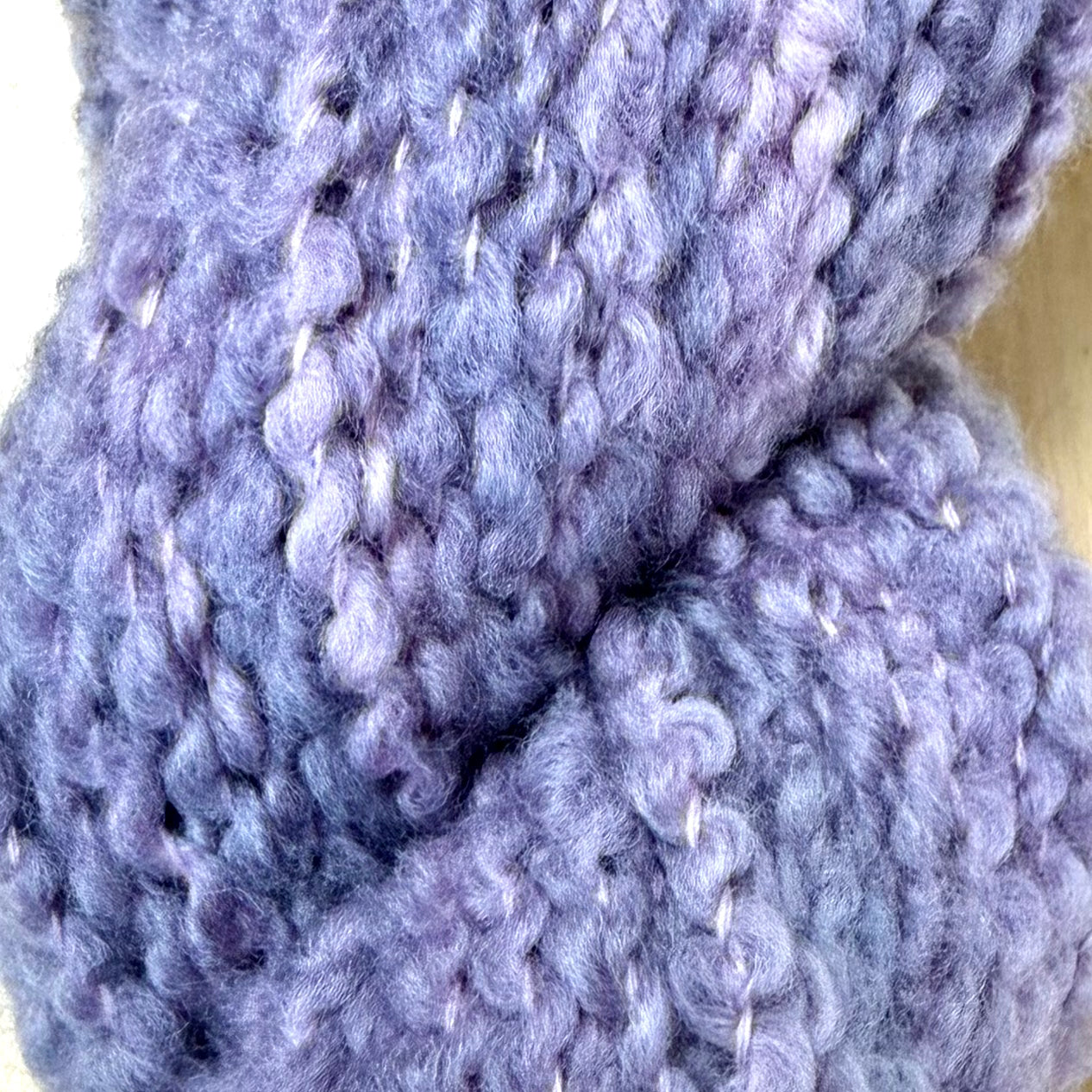 Hokuto by Apple Fiber Studio - A close-up of chunky knit yarn in a dusty lavender-purple color, showing the soft, fuzzy texture of the stitches.