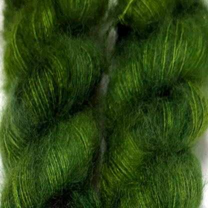 Delicious by Apple Fiber Studio. A close-up of bright green yarn skeins with subtle yellow-green highlights, filling the frame against a light background.