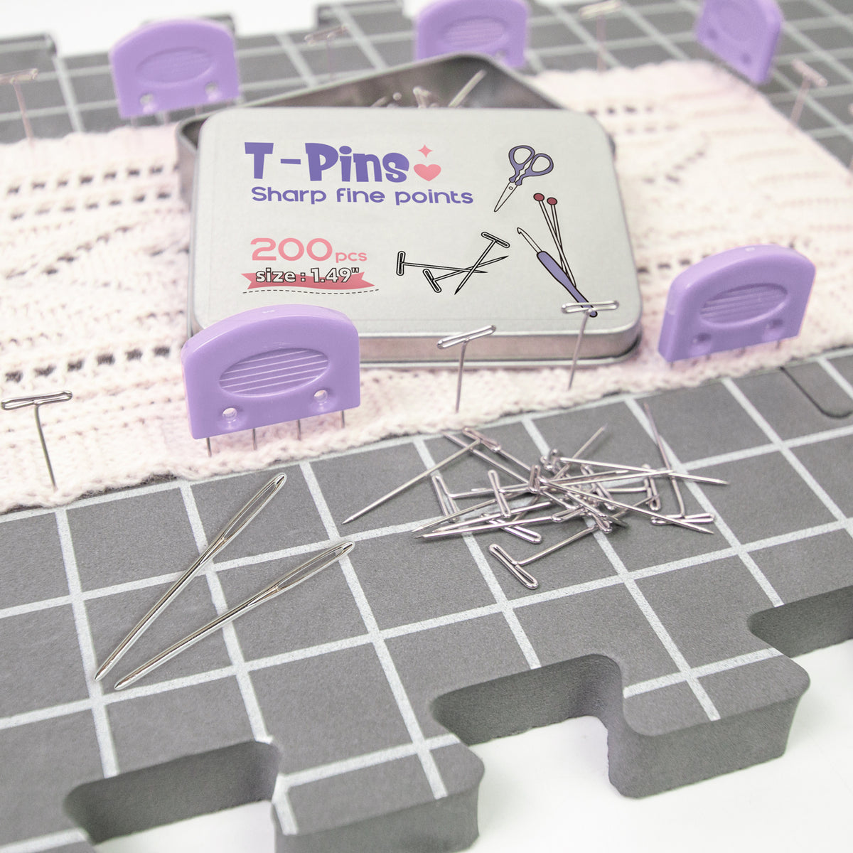 Blocking Matts - A tin of T-Pins Sharp Fine Points size 14G, 200 pieces, displayed with several loose silver pins and purple plastic pin holders on a gray grid mat.