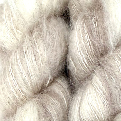 Close-up of fluffy, soft fibers in a pale warm gray-beige tone, filling the frame. Hand-dyed Cortland by Apple Fiber Studio in Alpaca and Silk at Apple Yarns.